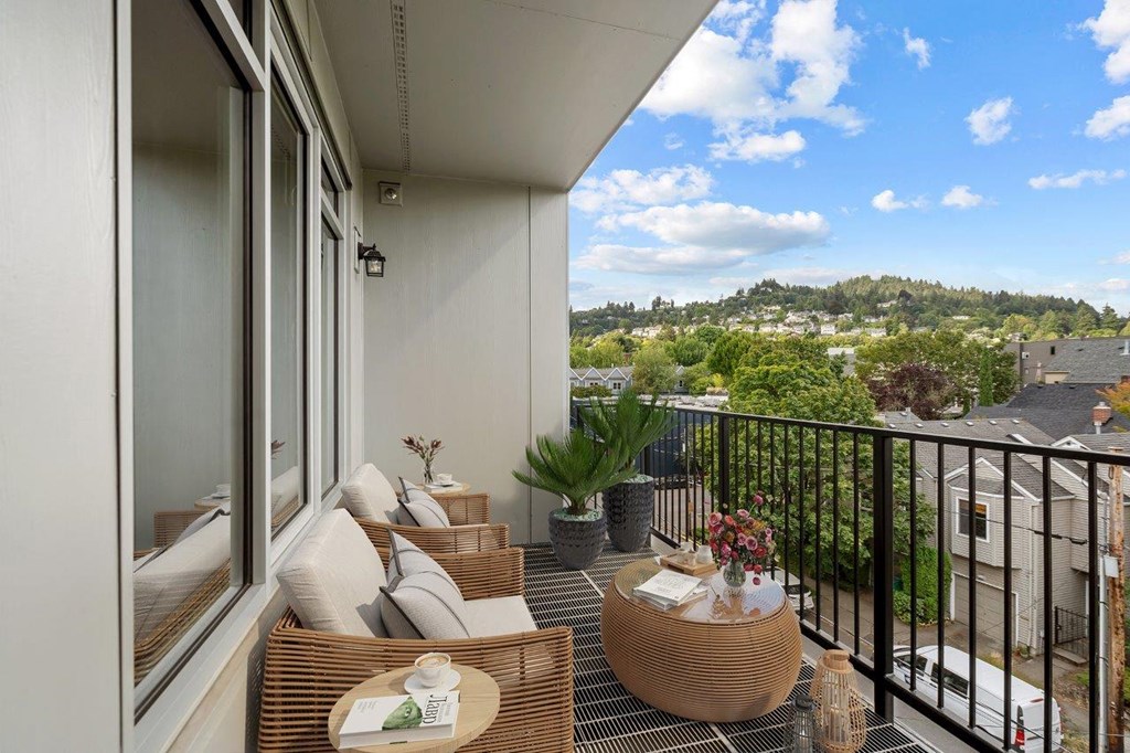 a balcony with a view of a city and a patio