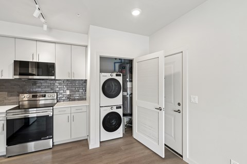 A modern kitchen with white cabinets and a stainless steel oven.