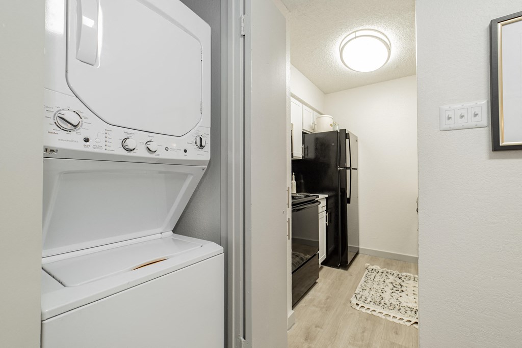 a laundry room with a washer and dryer and a kitchen