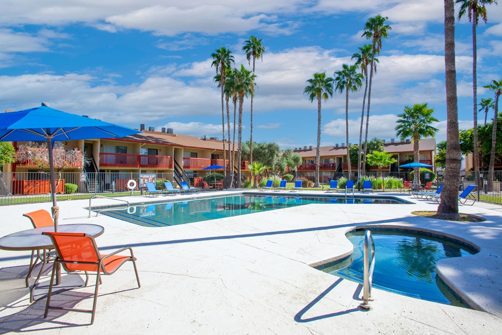 A pool surrounded by palm trees and chairs.