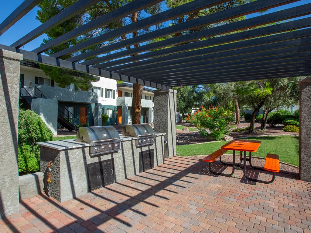 A patio with a table and chairs under a pergola.