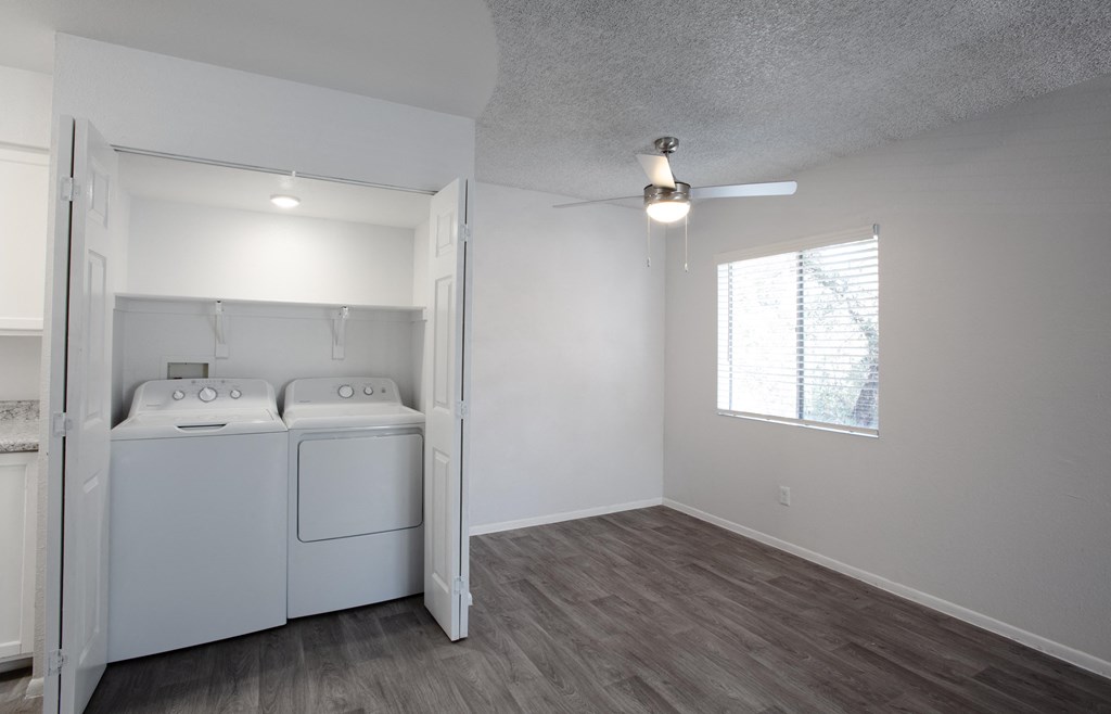 A laundry room with a washer and dryer built into a cabinet.