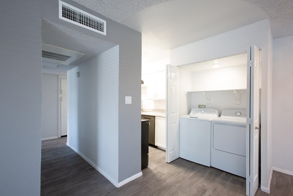 A small bedroom with a washing machine in it.