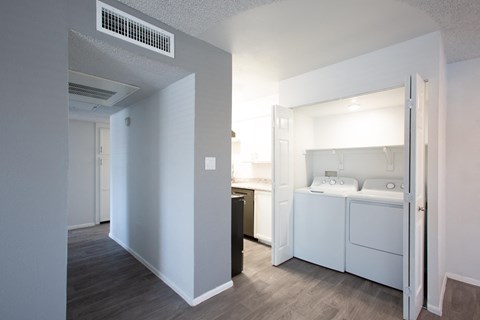A small bedroom with a washer and dryer in it.