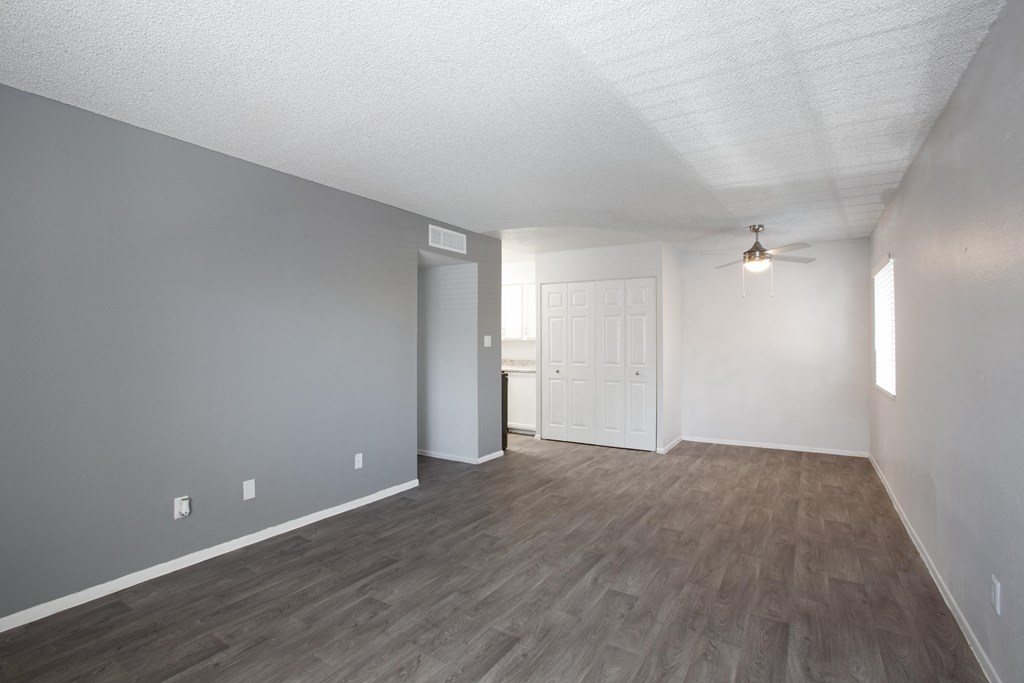 A room with a ceiling fan and a door.