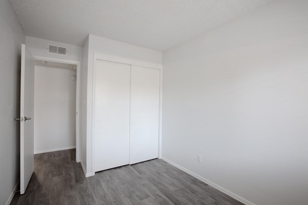 A room with a white door and a white closet.