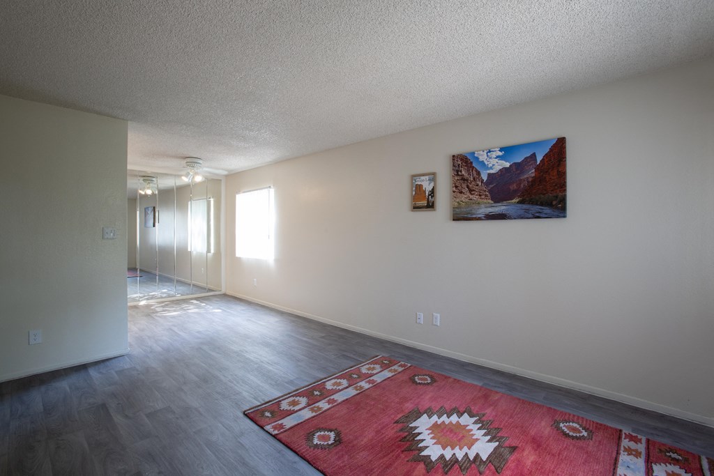 A room with a rug on the floor and a painting on the wall.
