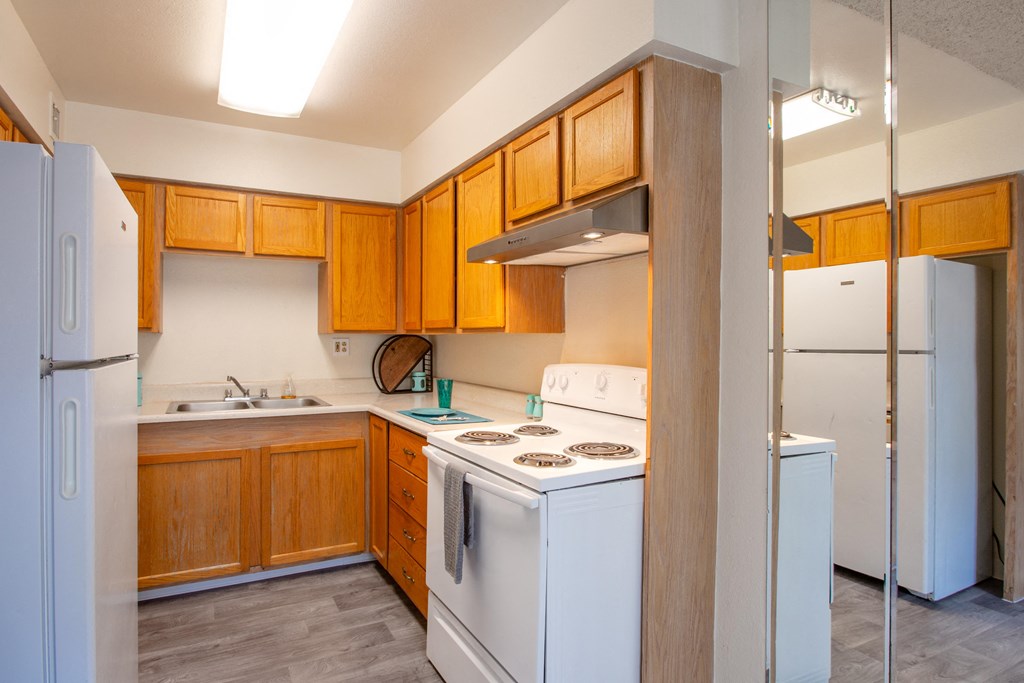 A kitchen with wooden cabinets and white appliances.