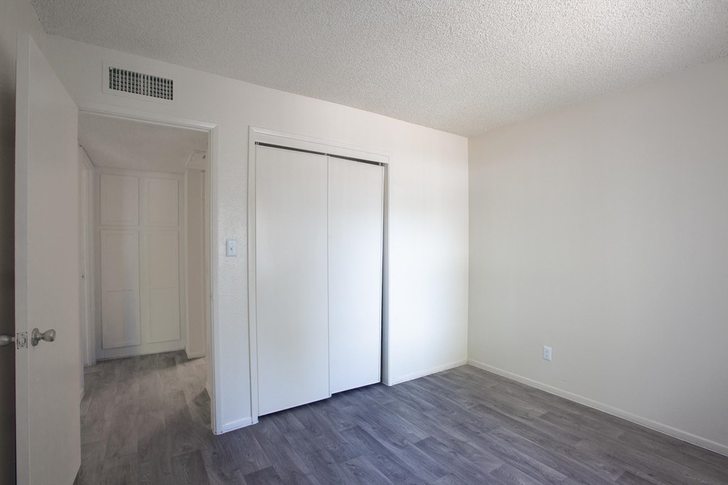 A room with a white door and a grey floor.