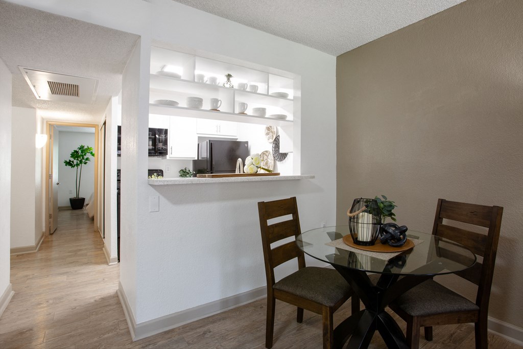 A dining room with a glass table and chairs.