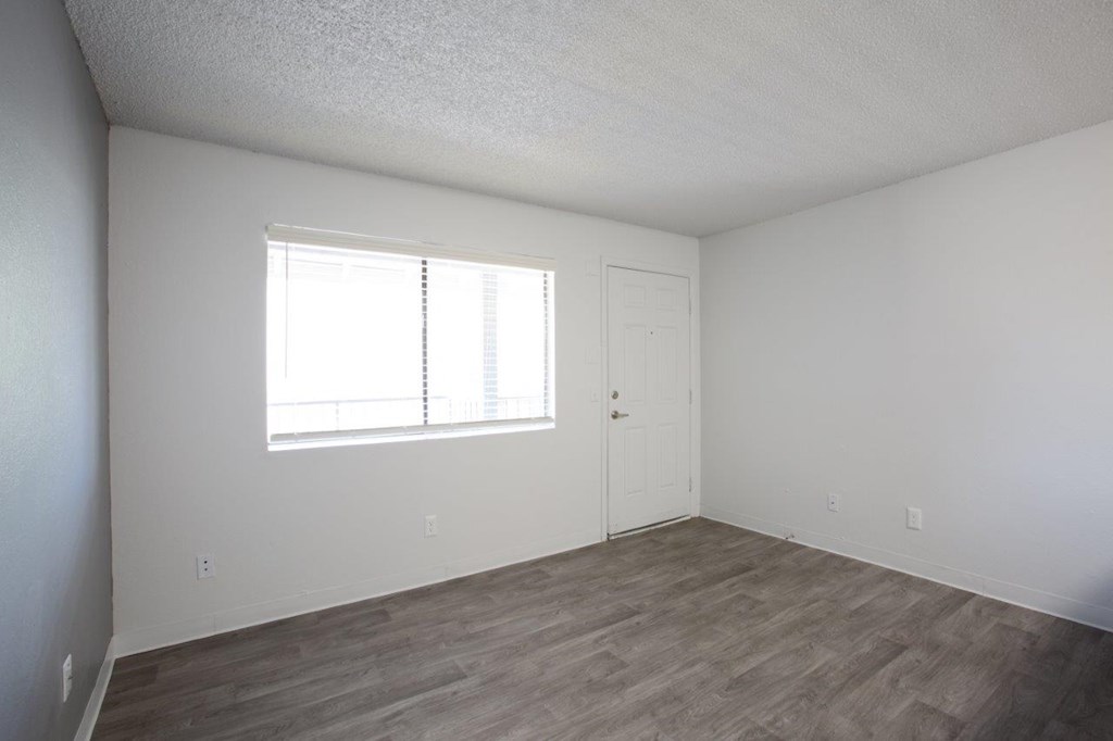A room with a wooden floor and a window.