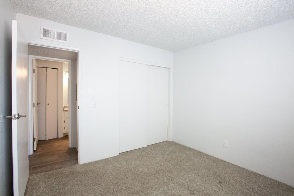 A room with a carpeted floor and a white door.