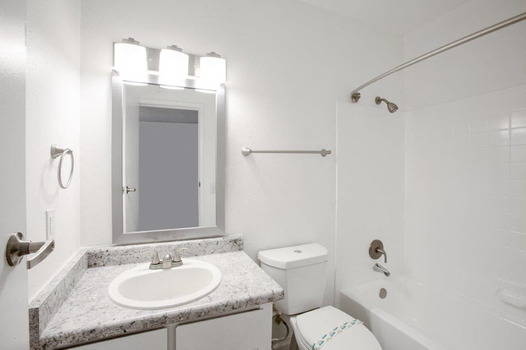 A white bathroom with a sink, toilet, and bathtub.
