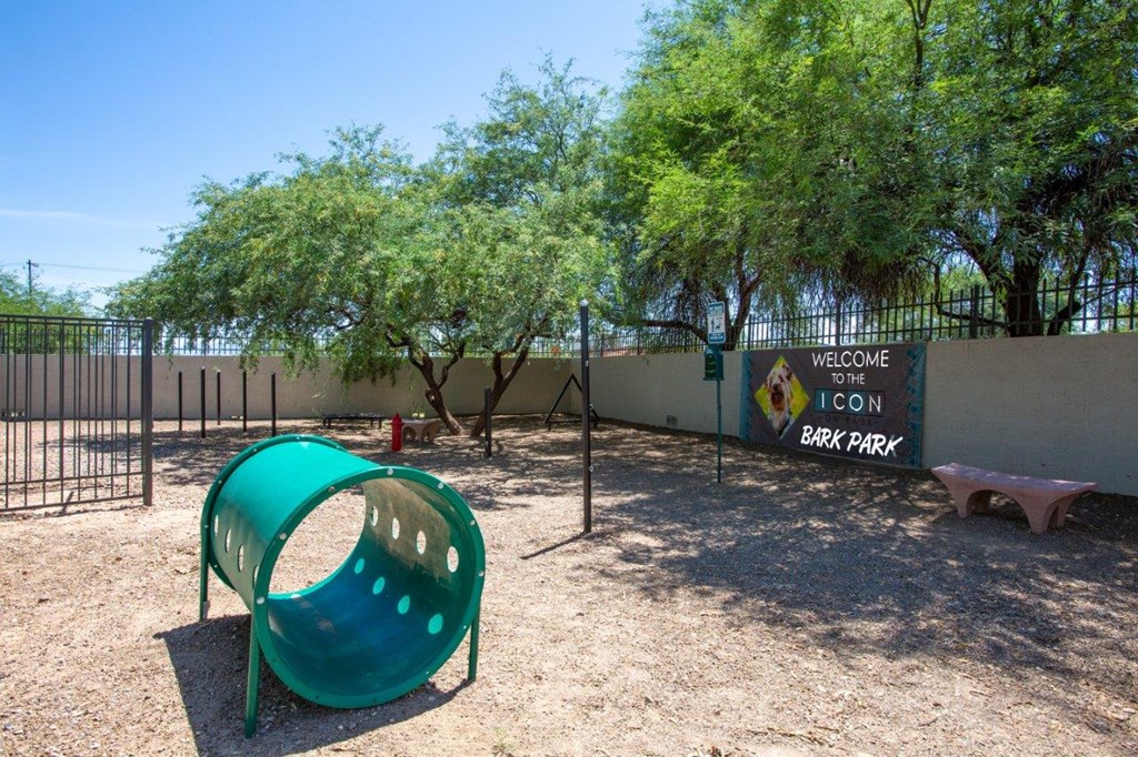 A playground with a green slide and a sign that says "Welcome to Bark Park".