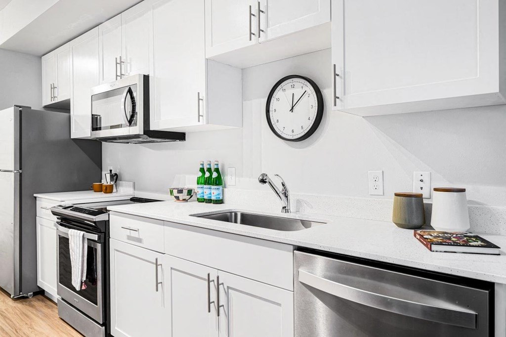 a kitchen with stainless steel appliances and a clock on the wall