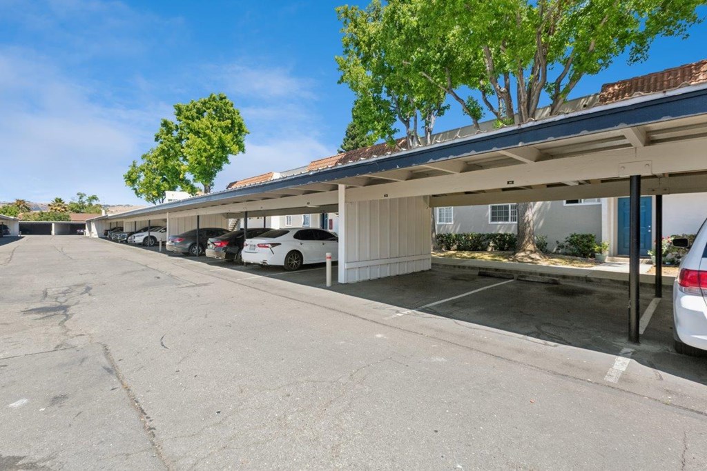 A covered parking lot with cars parked