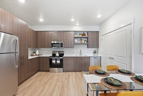 A modern kitchen with a dining table set for two.
