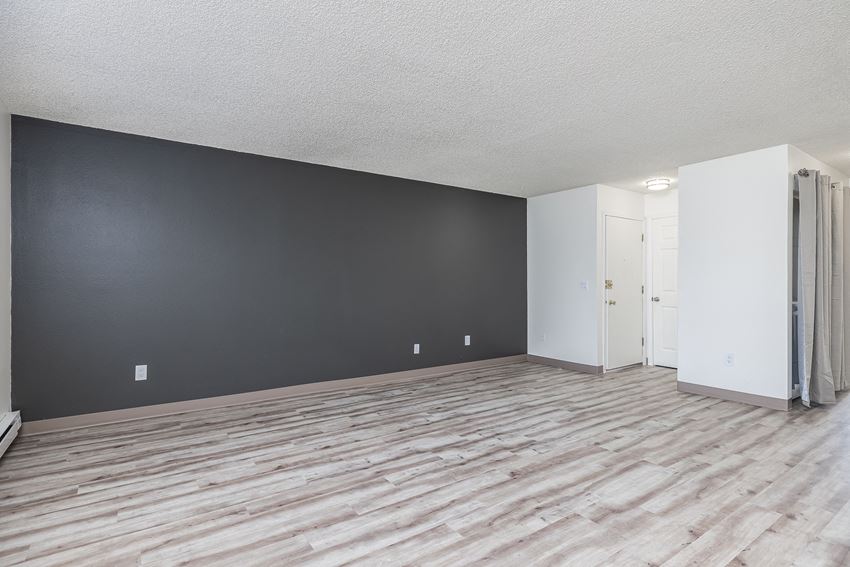 Hood Manor Apartments Living Room with Hardwood Flooring and Dark Gray Accent Wall - Photo Gallery