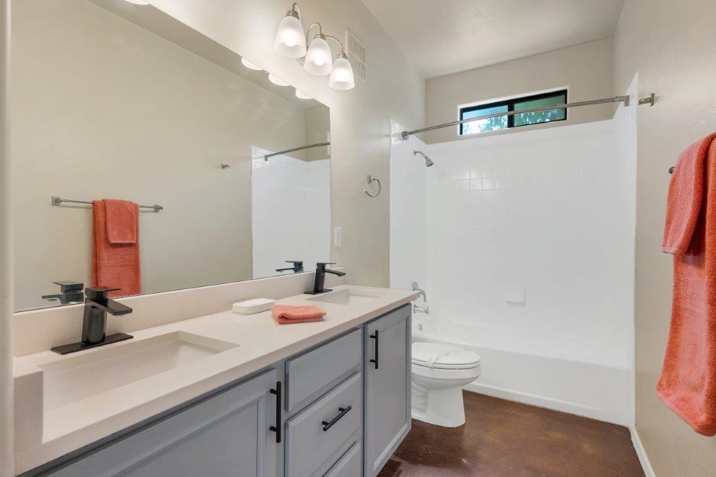 A bathroom with a white sink and a white toilet.