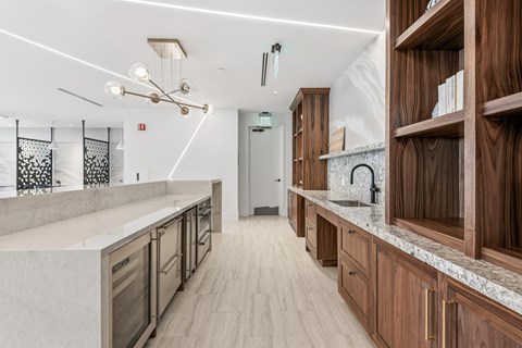 A modern kitchen with wooden cabinets and a marble countertop.