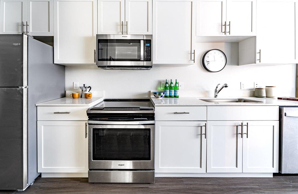 a kitchen with white cabinets and a stove and a microwave