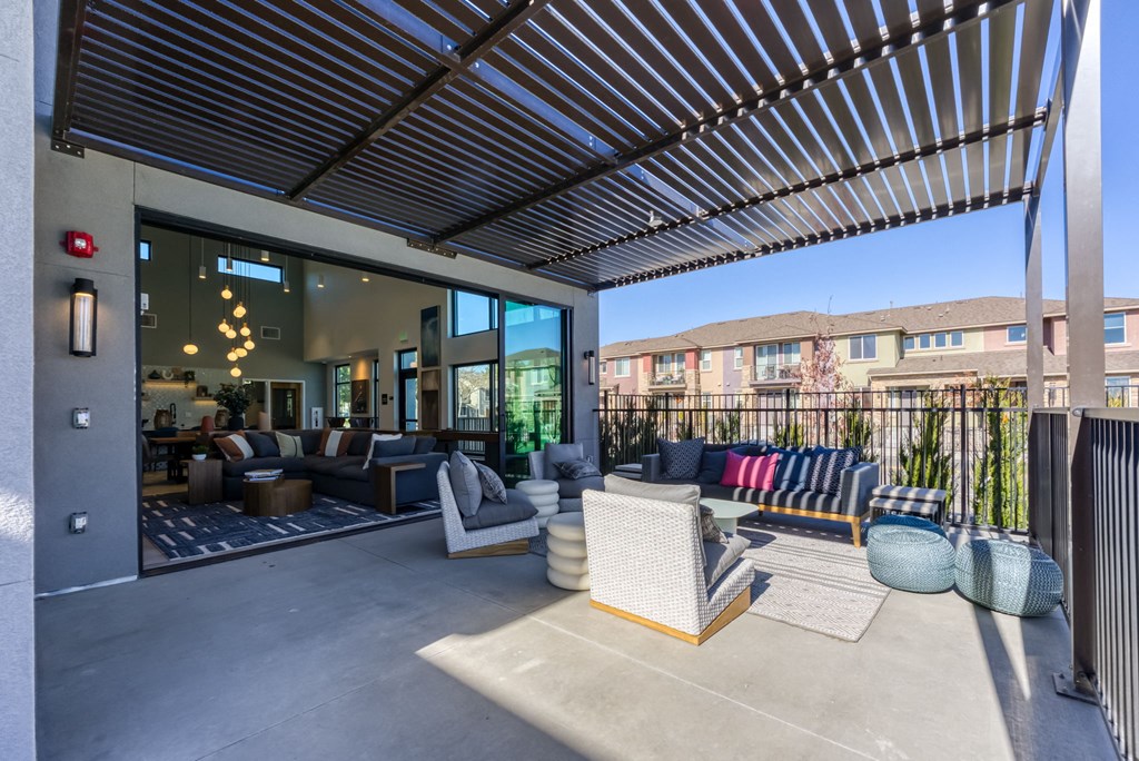 a communal area with couches and chairs on a patio