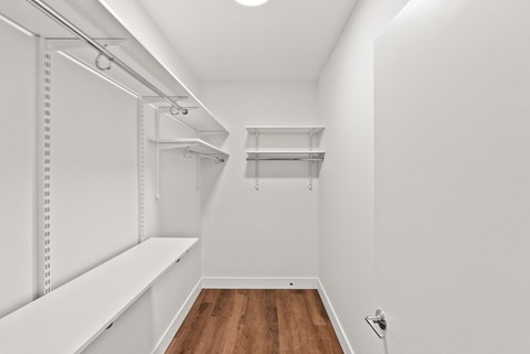 A white hallway with a wooden floor and white walls.