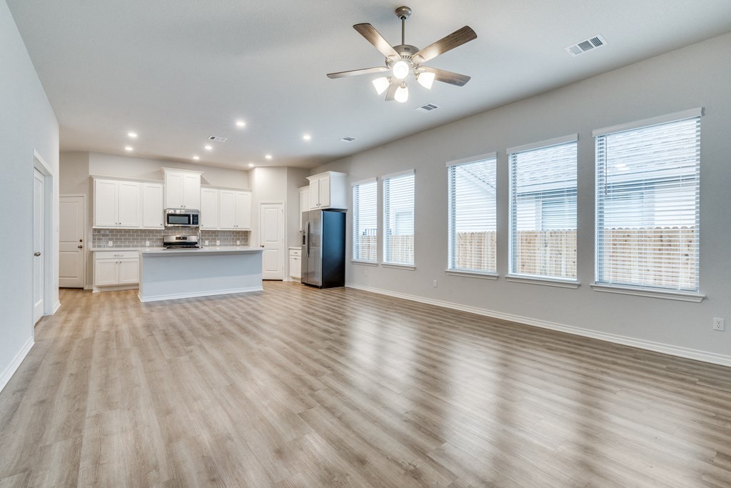 an open living room and kitchen with a ceiling fan