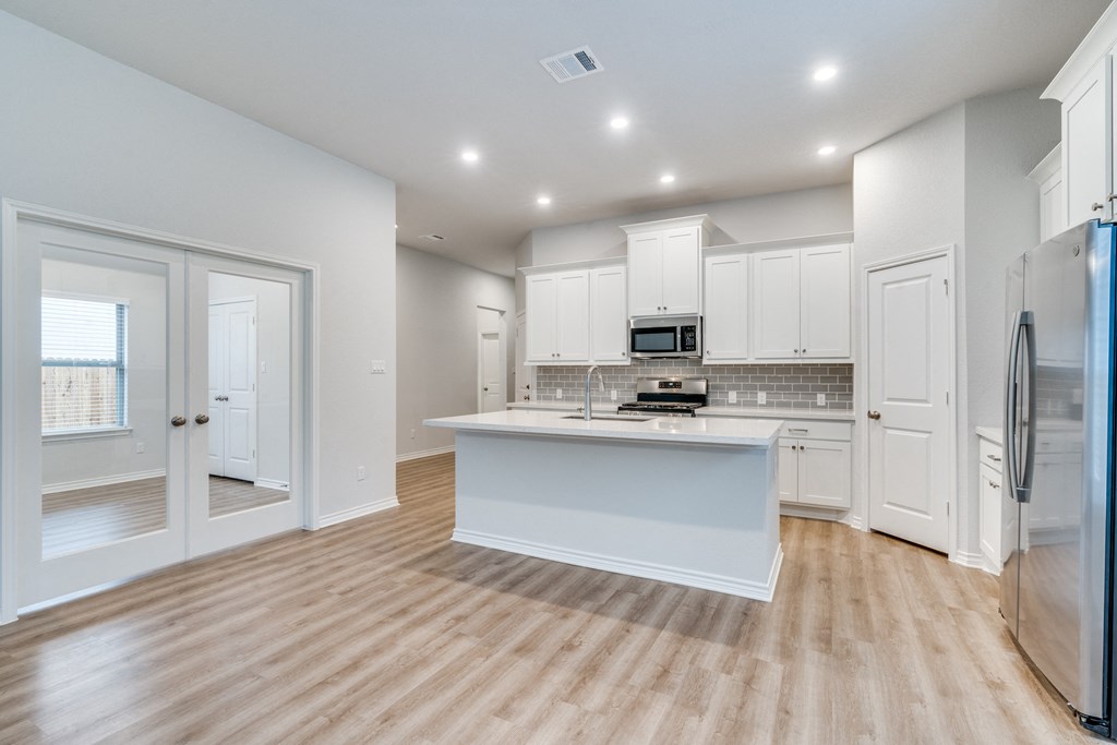 an open kitchen with white cabinets and a white counter top