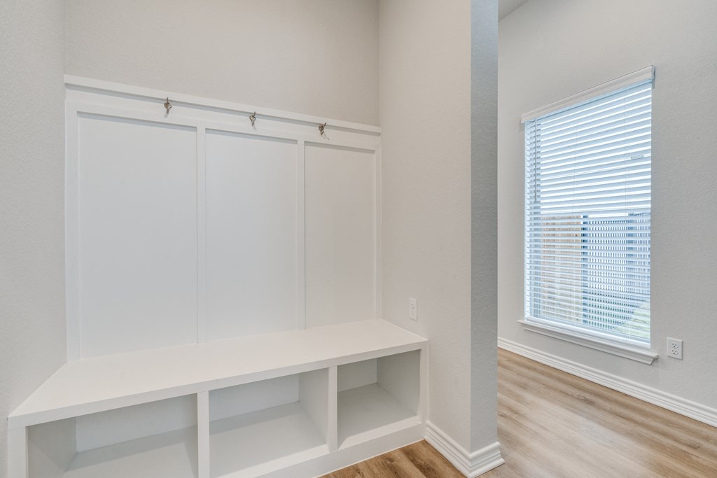 an empty room with white closets and a window