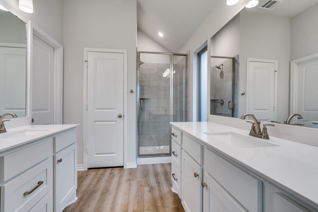 a white bathroom with two sinks and a shower