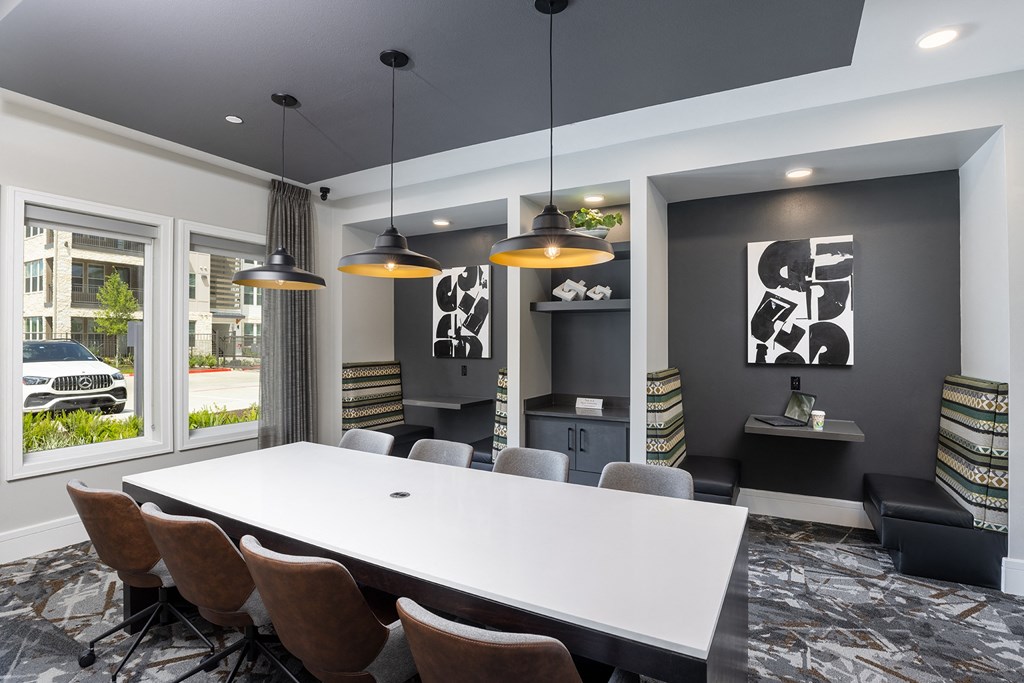 a meeting room with a large white table and chairs