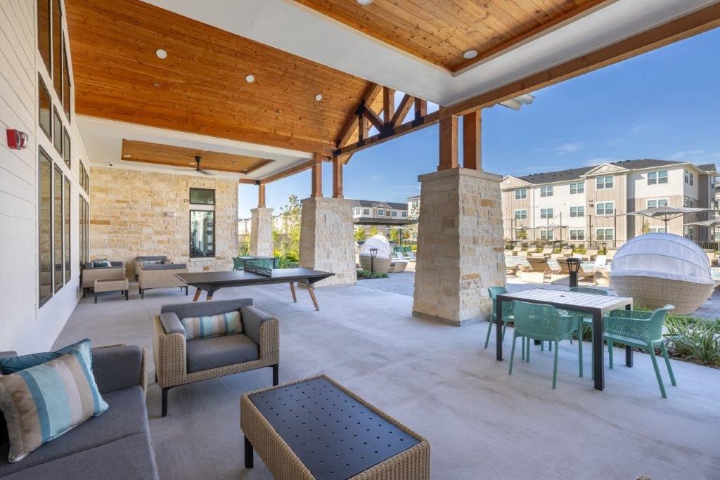 a large patio with tables and chairs and a building in the background