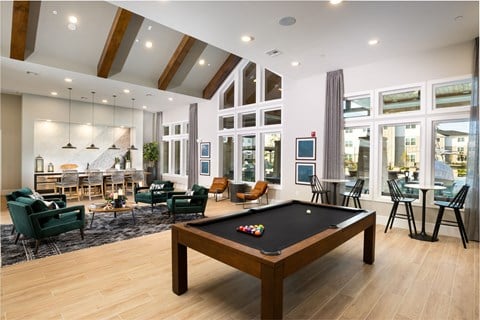 an open living room with a pool table in the center
