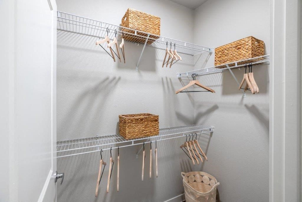 a walk in closet with baskets and utensils