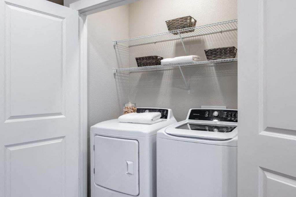 a white washer and dryer in a small laundry room