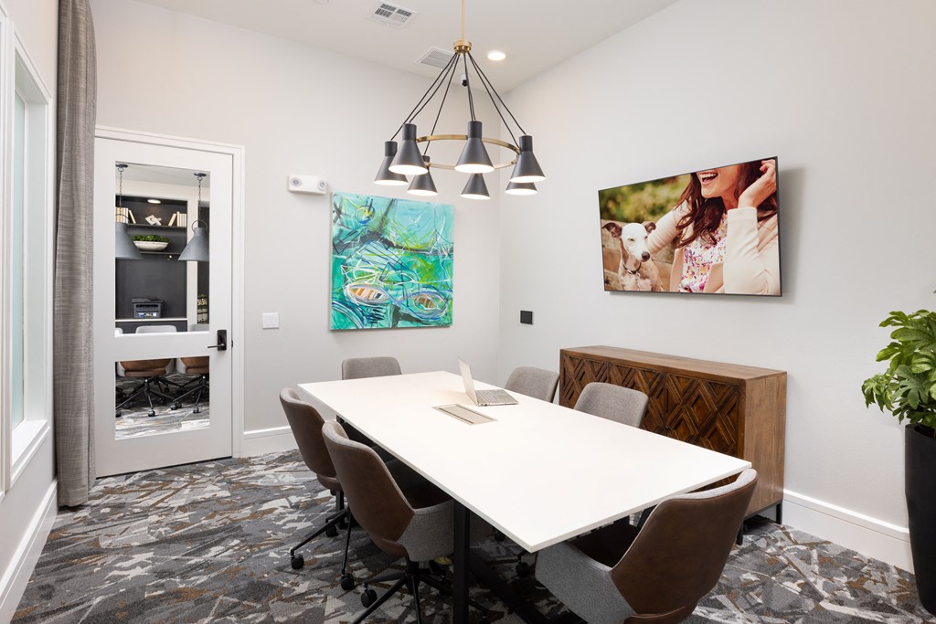 a meeting room with a white table and brown chairs
