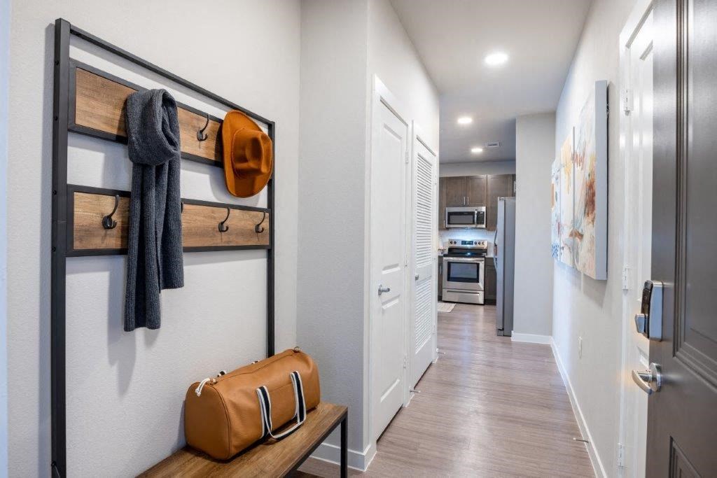 a hallway with a door to a kitchen and a closet