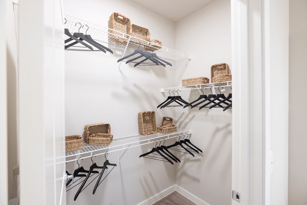 a walk in closet with baskets in a 555 waverly unit
