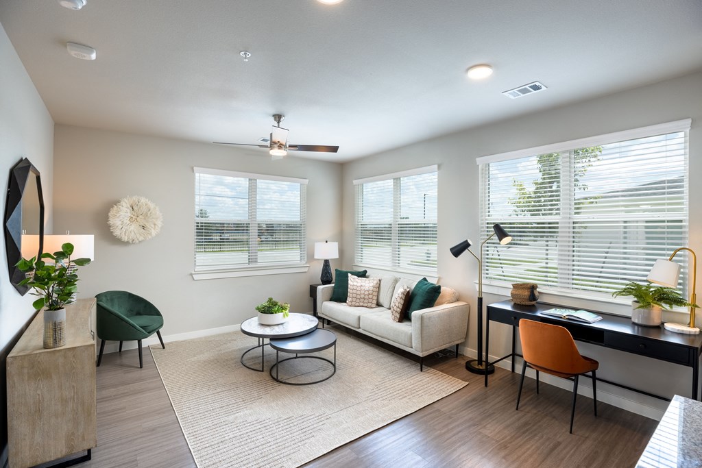 a living room with three windows and a couch
