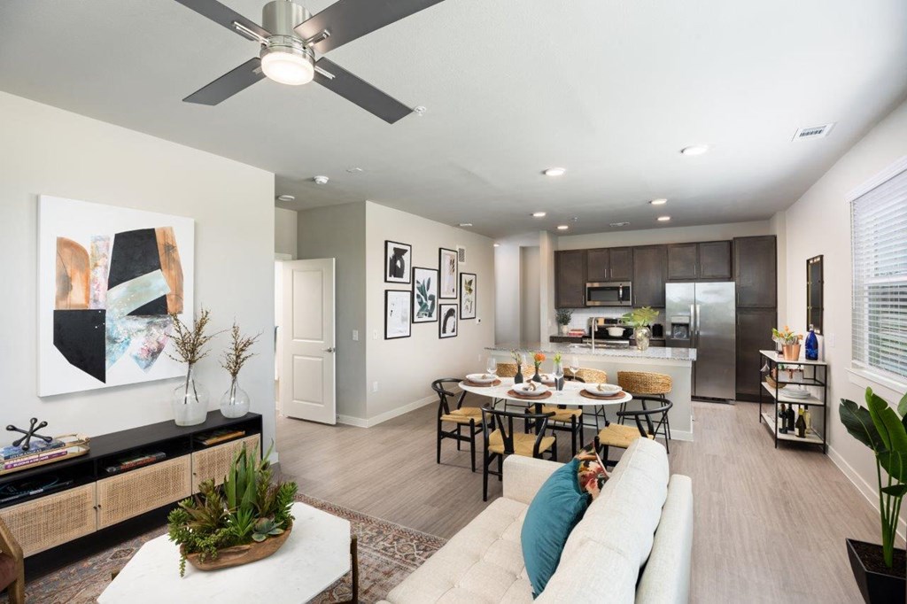 our apartments offer a living room with a couch a dining table and a kitchen with stainless steel