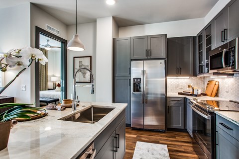 a kitchen with stainless steel appliances and marble counter tops