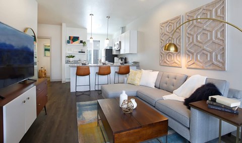 A modern living room with a grey couch and a wooden coffee table.
