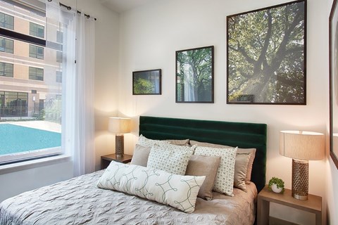 A bedroom with a large bed and a green headboard.