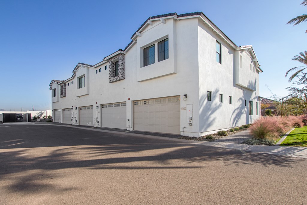 A large white house with a garage door and a driveway.