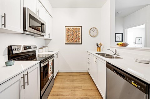 a kitchen with white cabinets and stainless steel appliances