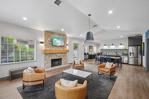 A modern living room with a stone fireplace and a painting above it.