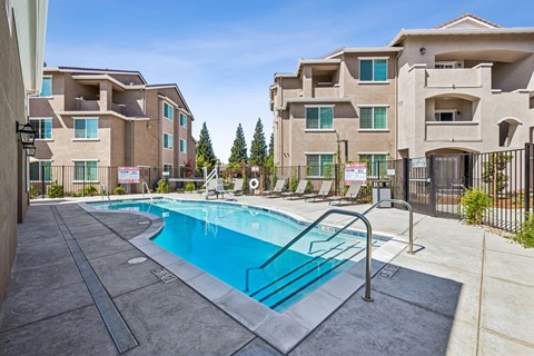 A swimming pool in front of apartment buildings.