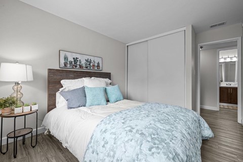 A bedroom with a bed covered in a blue and white patterned duvet.
