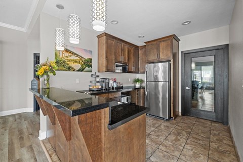 A kitchen with a black counter top and wooden cabinets.